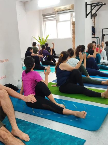 Students practice Ardha Matsyendrasana (Half Lord of the Fishes Pose), a seated twist that energizes the spine and stimulates the digestive organs.