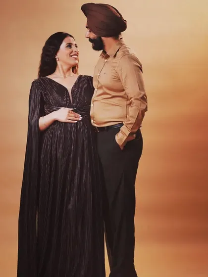 This lovely couple from Patiala chose one of my gowns for their studio maternity shoot. The dark, pleated cape dress offers an elegant and timeless look that photographs beautifully against a simple backdrop.