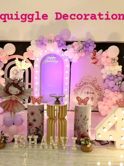 A magical butterfly and fairy themed birthday decoration in shades of pink and purple. This enchanting setup features large butterfly wing props, a light-up marquee number '4', a unicorn cutout, and whimsical balloon arrangements for a truly special celebration.