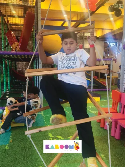 Up the rope ladder! This climber is determined to reach the top of our play structure.