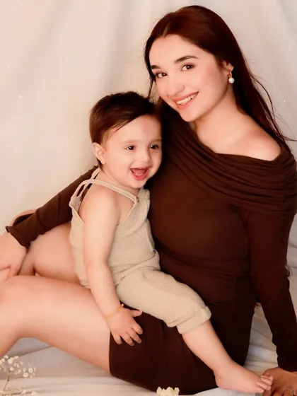 A close-up portrait of a mother and her smiling son. This intimate framing highlights their joyful expressions and the strong emotional connection between them.