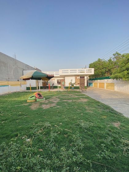 A look at our play area, complete with an umbrella for shade and colorful tires for the dogs to play on.