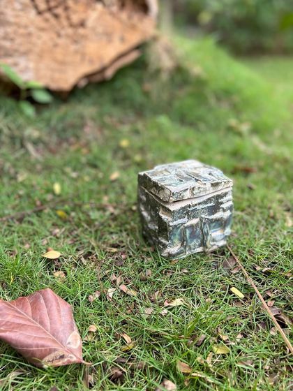 A stoneware box made using the Japanese 'kurinuki' technique, which involves carving the form from a solid block of clay. This method results in beautifully rugged, rock-like textures.
