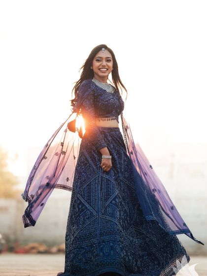 Another joyful twirling shot of Dr. Akshara against the setting sun. The backlighting creates a beautiful halo effect, making her look ethereal.