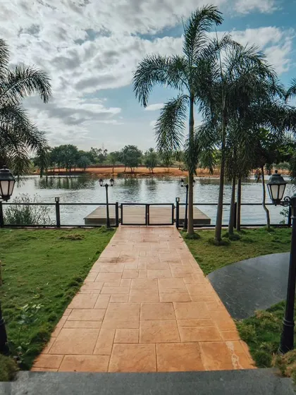 A beautiful pathway leading down to the lake, lined with palm trees and vintage-style lamps. It's one of the most picturesque spots in the resort.
