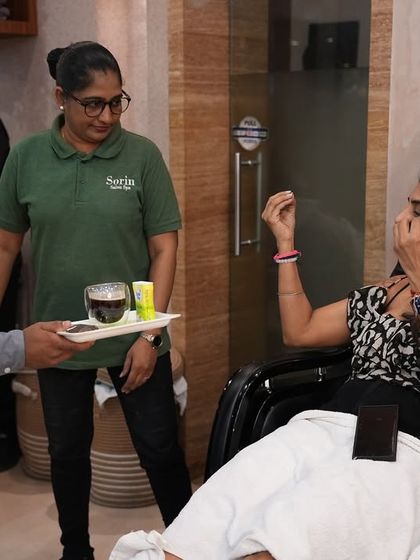 Our staff is dedicated to providing attentive and caring service. A team member serves a welcome drink to a client settled in for her pedicure, ensuring she feels pampered from start to finish.