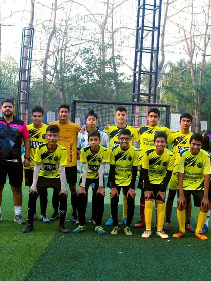 The senior team stands with their coaches, a testament to years of hard work and development within the academy.
