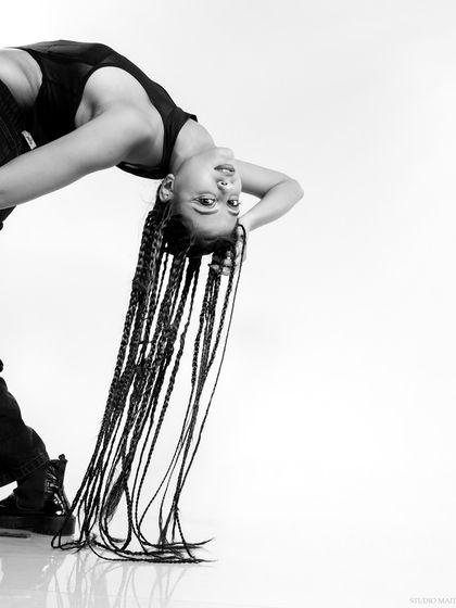 A playful, inverted pose from the braids series, showcasing creativity and movement.
