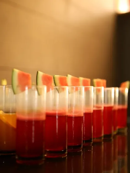 A row of refreshing watermelon juice glasses, garnished with fresh fruit slices. We believe in starting every event on a fresh note with our beautifully presented welcome drinks.