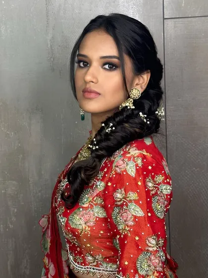 A powerful and intense look for a Mehendi ceremony. I created a dramatic smokey eye to complement the vibrant red outfit, paired with a soft, intricate braid adorned with baby's breath for a touch of romanticism.