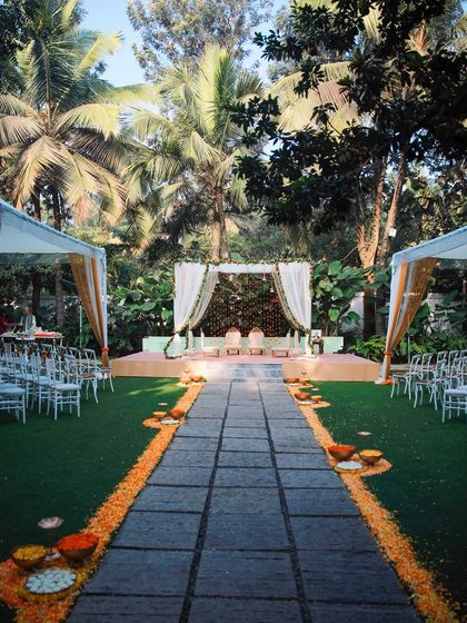 A collection of stunning wedding setups at The Farmhouse Collective. You can see the venue's versatility, from elegant morning ceremonies with floral mandaps to glamorous evening receptions with fairy lights and chic decor. This space is a blank canvas for your dream outdoor wedding in Bengaluru.