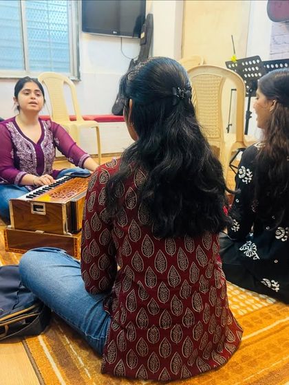 Another view of our Hindustani vocal class, showing the intimate and focused setting. The coach guides students through exercises on the harmonium, ensuring each student receives personal attention.