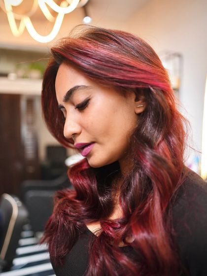 Vivid red vibes only. This look on Urvashi Cardoz showcases a magical red hair color that is both intense and full of dimension, styled with soft waves to complete the look.