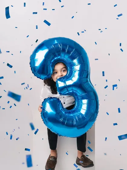 A dynamic shot with confetti. Even in a minimalist studio, we can add elements of fun and action to create exciting birthday photos.