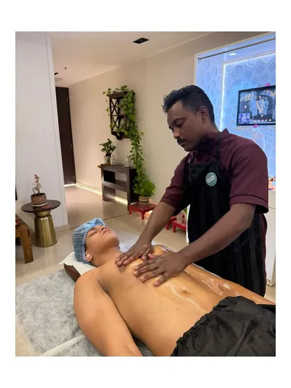 Our trained therapist performing an Abhyangam chest massage at a client's home. We ensure every session is professional, hygienic, and focused on your complete relaxation.