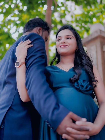 This couple opted for an outdoor maternity shoot. The father-to-be's navy suit looks sharp against the natural backdrop, showing the versatility of our rental collection.