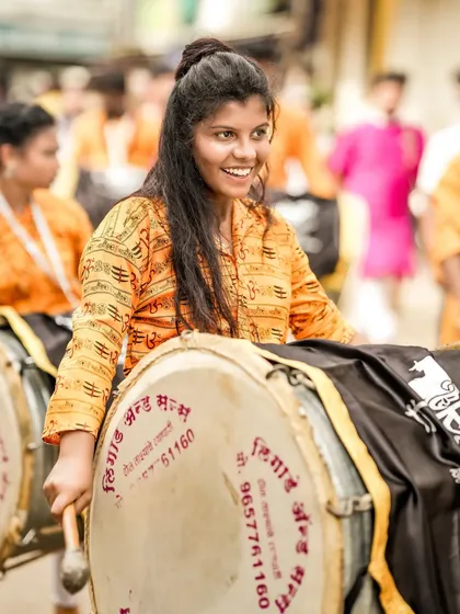 The color version of the smiling female dhol player.