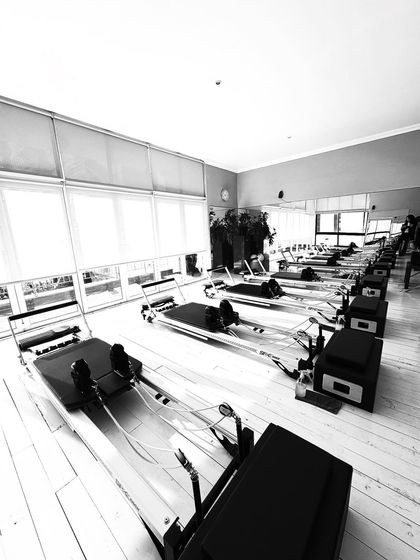 A room full of reformers, full of potential. This image from my travels inspires me, representing the endless possibilities for strength and healing that Pilates offers.