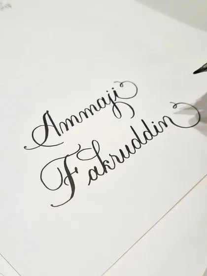 Practicing some names before the event rush. Preparation is key to ensuring every piece of calligraphy is crafted with care, even in a busy retail environment.