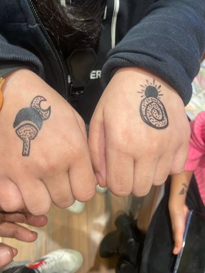 Matching anime-themed tattoos for two friends. This is a fun way for guests to share a party experience.