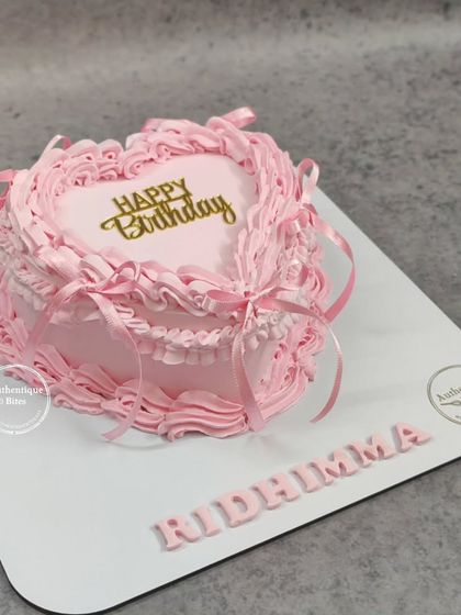 A simple and beautiful vintage heart cake in a soft pink color. The detailed piping and "Happy Birthday" in gold script make it an elegant choice.