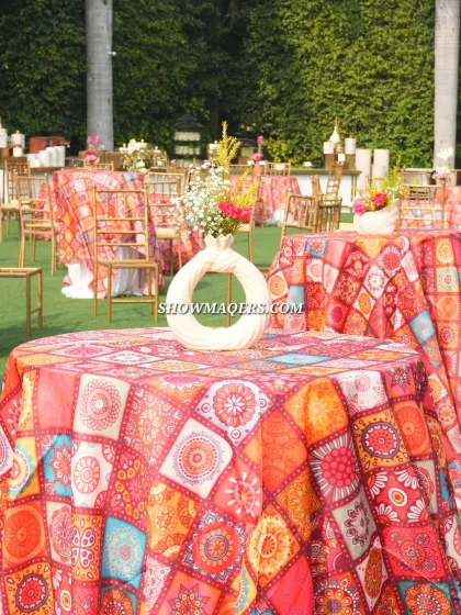 Close-up of the vibrant, patterned tablecloths and simple floral centerpieces used in the guest seating area.