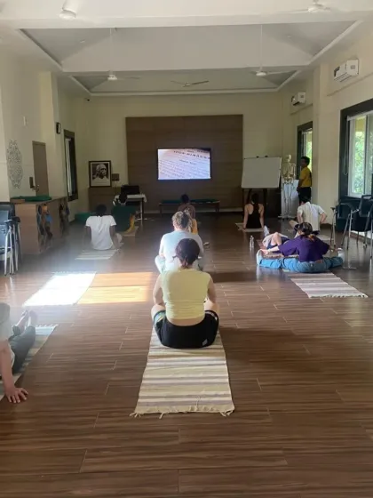 Students from Adelphi University are seated on their mats, listening to an instructor. This image captures the learning environment where students engage with authentic yogic practices in a disciplined setting.