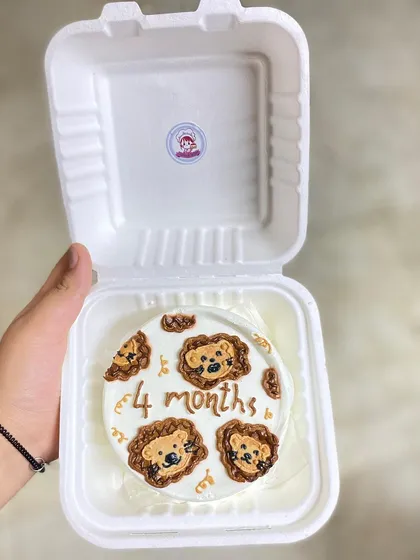 A hand-held shot of the lion bento cake, giving a sense of its personal, giftable size.