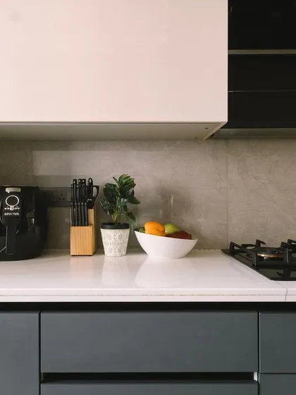 The kitchen countertop is kept clean and functional, with a simple color palette of grey and white that creates a sense of calm and openness.