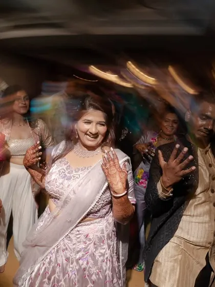 A candid shot of the bride enjoying the sangeet, surrounded by her dancing friends.