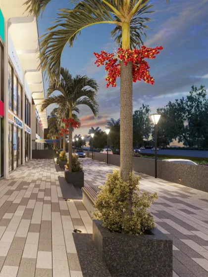 A close-up of the landscaped promenade outside the mall, designed with patterned paving, benches, and palm trees to create a pleasant public space.