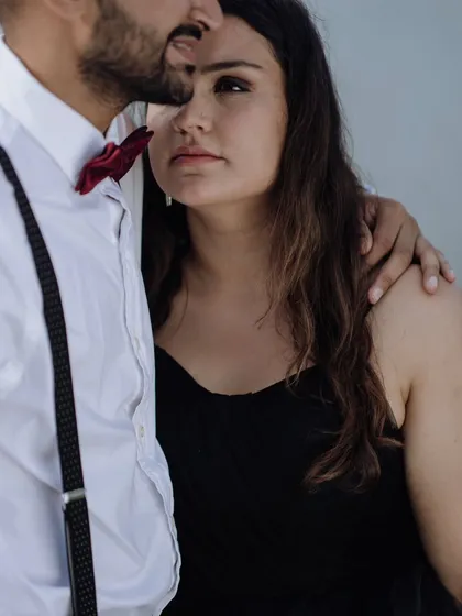 A close-up portrait showing the bride's thoughtful expression as she rests her head on her partner's shoulder.