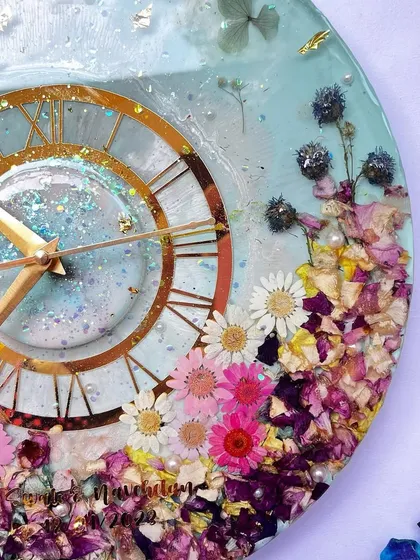 This 12-inch clock is so vibrant. The mix of preserved daisies and other colorful flowers against a light blue background is perfect for a spring or summer wedding.