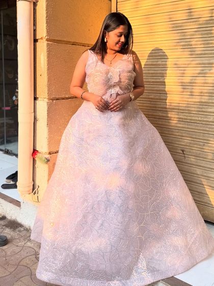 A beautiful client looking like a princess in this light pink ball gown. It's perfect for a reception, engagement, or any grand celebration.