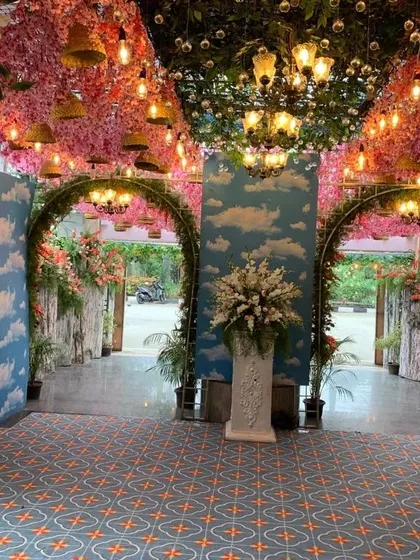 I transformed this naming ceremony venue into an enchanting paradise with a ceiling of pink blossoms, hanging lights, and walls painted like a blue sky, showing how a unique theme can be brought to life.