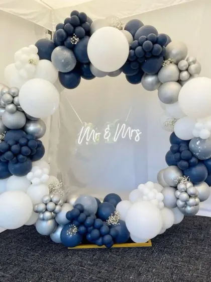 A "Mr & Mrs" balloon hoop for a wedding or anniversary. The navy blue and white balloons create a classic and timeless color combination, with a neon sign in the center.