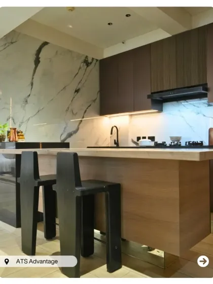 A luxurious open-concept kitchen in a penthouse. It features a marble backsplash, a functional island with stylish bar stools, and integrated lighting for a high-end culinary experience.