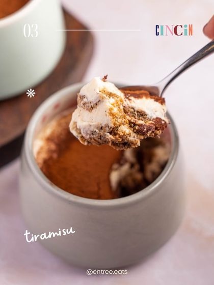 A close up shot of a spoonful of tiramisu, showing the creamy, layered texture. This image is all about the sensory experience, making the viewer imagine the taste and feel of the dessert.