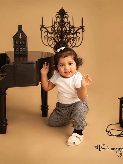 A joyful performance. This shot captures the happy expression of a toddler enjoying her time at the piano, creating a lively and engaging portrait.