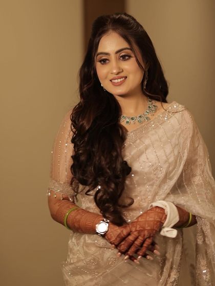 The complete engagement look. Her ivory saree is paired with a soft, luminous makeup style that enhances her features without overpowering them, creating a truly timeless appearance.