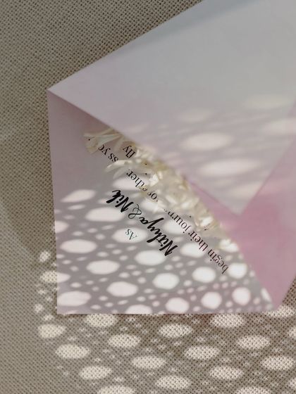 A cone of flowers for guests to shower the couple, with the sunlight creating a beautiful shadow pattern through a jaali screen.