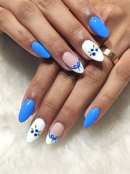 A cute and classic blue and white set. This design features solid blue nails paired with white accent nails adorned with hand-painted blueberries and a delicate bow.