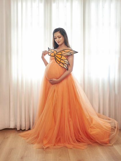 Another view of our butterfly-themed look. The orange tulle gown and wing accessory create a truly one-of-a-kind maternity photo.