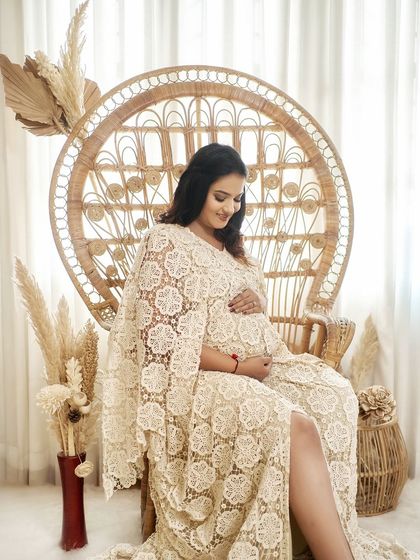 A serene portrait of a client in our Juene lace kaftan. The peacock chair and pampas grass create the perfect boho-chic setting.