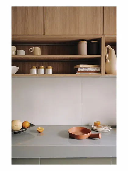 The kitchen is revealed through glass screens that open like a shoji, connecting it to the dining area. This detail shows the olive green and wood-clad cabinetry, a part of our commitment to using natural colors and materials even in functional spaces.