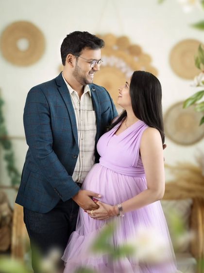A sweet, interactive shot of a couple looking at each other, framed by the soft greenery of our studio.