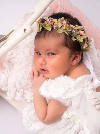 A baby girl with an alert expression, nestled in a tiny bed. Her gaze is captivating and shows her emerging personality.