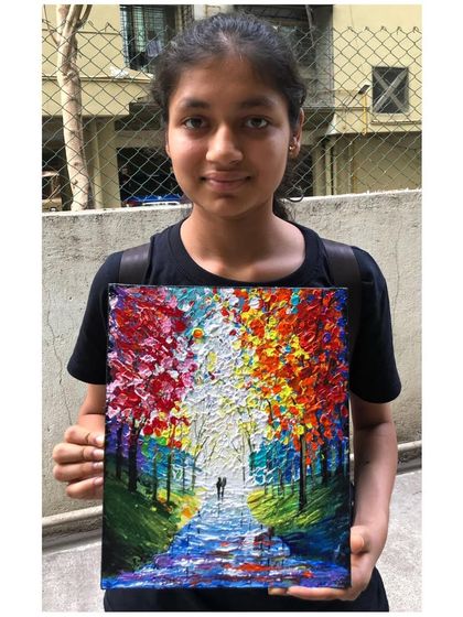 A student holds her breathtaking "Walk To Remember" canvas painting, a piece full of texture and vibrant autumn colours that create a sense of romance and nostalgia.