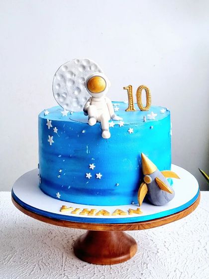 A full view of the space-themed cake on its stand.