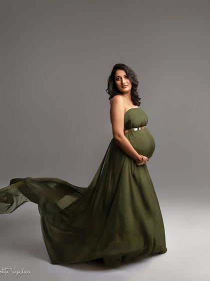 An olive green gown with a flowing train. The color is unique and earthy, and the pose is strong and confident.